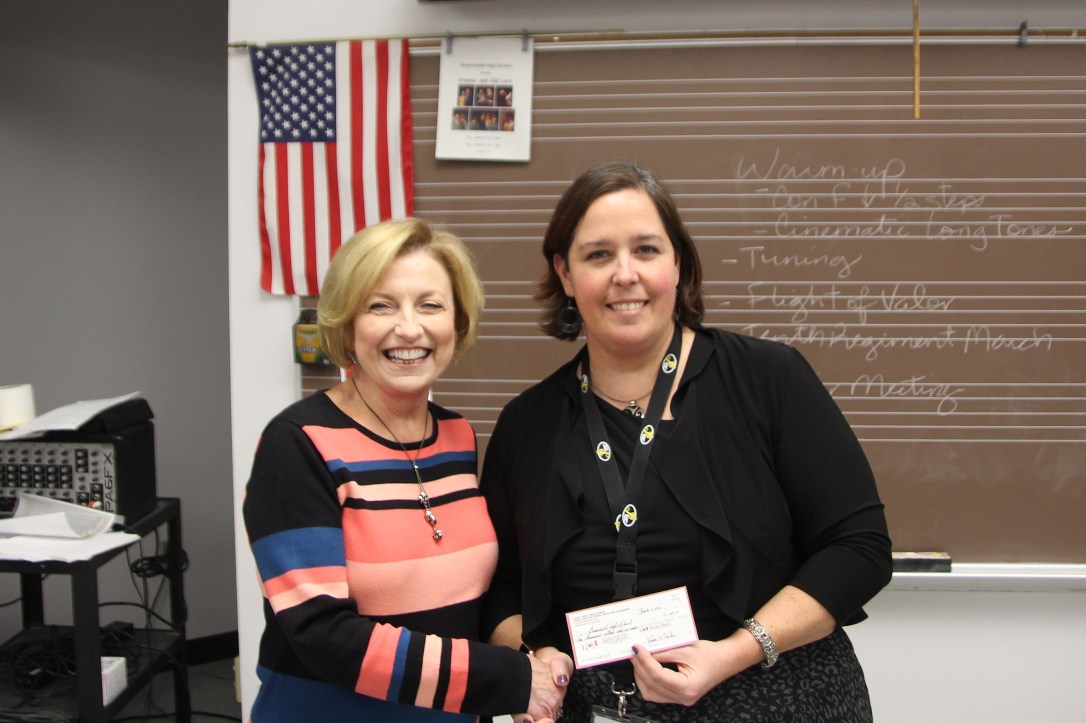 Linda Huber handing off check to GHS band director Annette Munoz