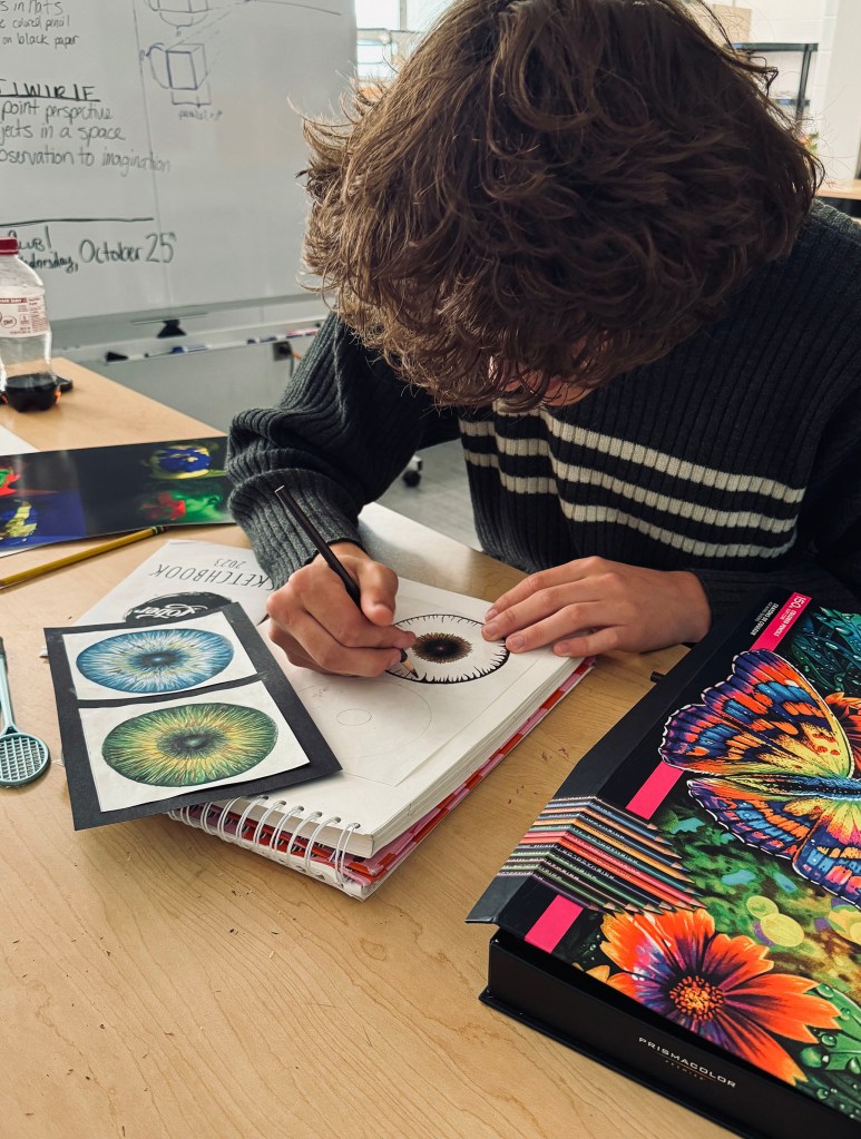 Greencastle High School student drawing with colored pencils in art class.